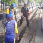 Peduli Kebersihan, Babinsa Serda Hilmi Bantu Pekerja PUPR Bersihkan Gorong-gorong